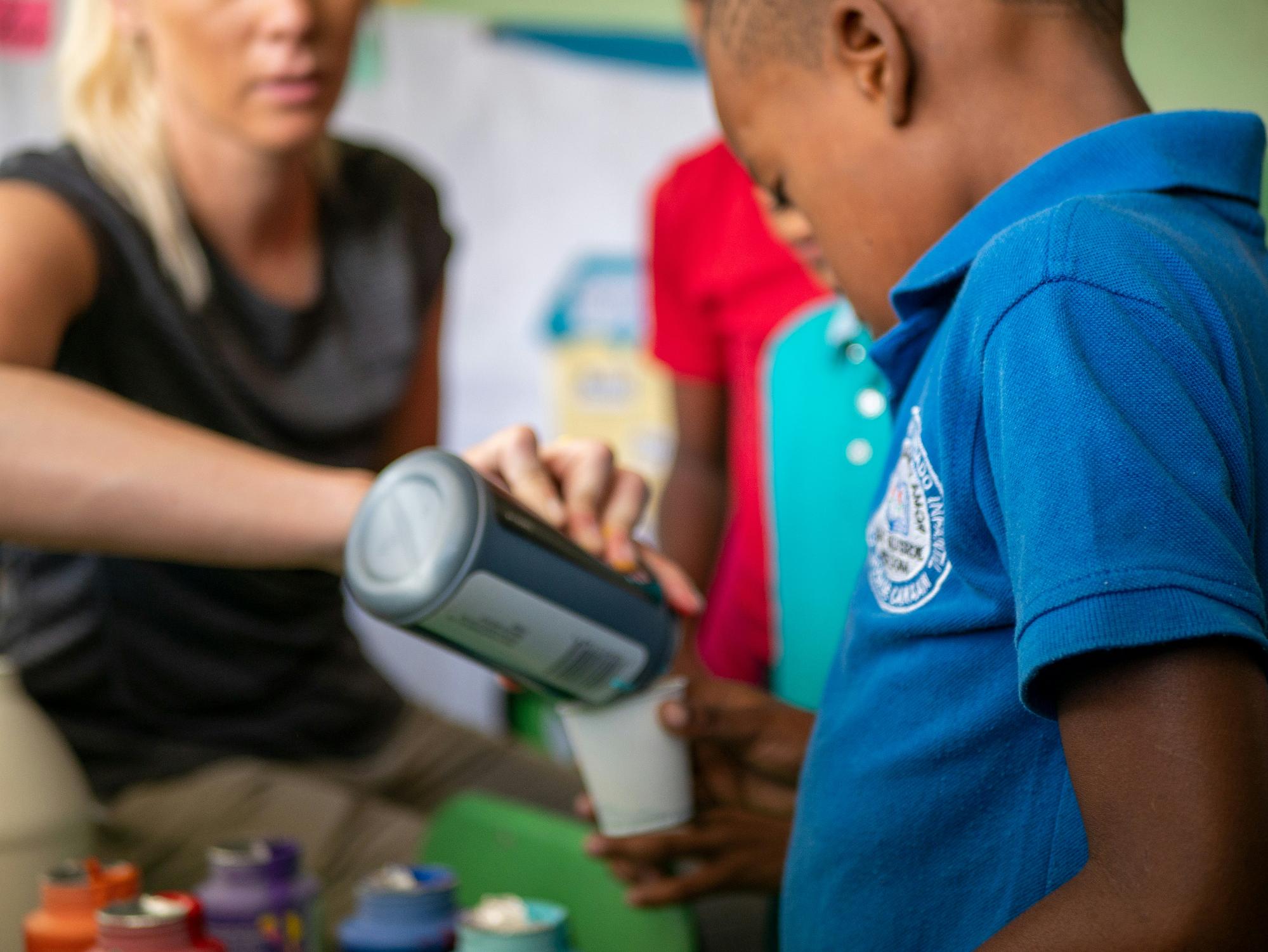 a person pouring a liquid into a container